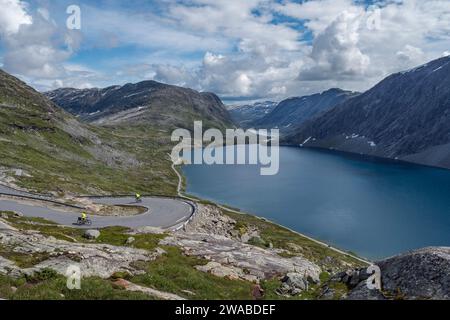 Radfahrer fahren in Richtung Djupvatnet die Straße hinunter vom Aussichtspunkt Dalsnibba zum See, Geiranger, Norwegen. Stockfoto