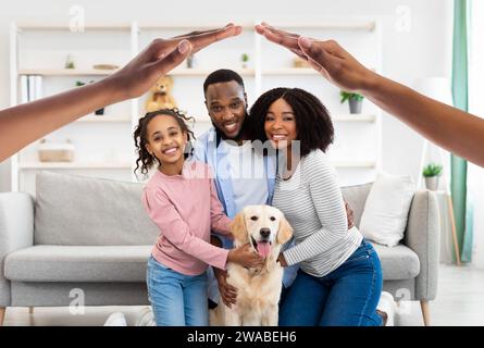 Glückliche schwarze Familie posiert mit Hund zu Hause Stockfoto