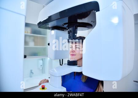 Glückliche Patientin macht einen Panorama-Computertomographen in der Klinik. Zahnheilkunde und Gesundheitskonzept. Stockfoto