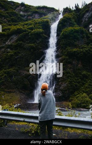 Frau steht vor dem Wasserfall in Valdez, Alaska. Stockfoto