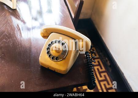 Altes Telefon in schwarzer Farbe auf Holztisch. Klassisches Retro-Drehrad im Vintage-Stil, Telefonnummer. Altes Telefon, Retro, altmodisches Telefon Stockfoto