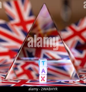 Eine Kristallpyramide neben Blockbuchstaben, in denen STEUERN, Zukunft der Steuern beschrieben werden, mit dem Hintergrund der Flagge der Union Jack, UK Tax, United Kingdom Tax Stockfoto