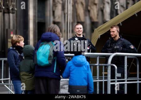 Polizisten an den Einlassschleusen vor dem Kölner Dom. Terroralarm zum Jahreswechsel: Nachdem Silvester rund um den Kölner Dom 1000 Polizisten auch mit Maschinenpistolen im Einsatz waren, werden die Sicherheitsregeln weiter aufrecht erhalten. Es gelten verstärkte Sicherheitsmaßnahmen nach einer Terrorwarnung vor Weihnachten. Hintergrund: Eine islamistische Terrorzelle des afghanischen ISIS-Ablegers ISPK soll über den Jahreswechsel u.a. in Köln Anschläge geplan haben. Für Touristen bleibt der Dom weiter geschlossen. Besucher von Messen oder lange im Vorfeld gebuchten Führungen müssen ein Screen Stockfoto