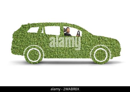 Mann, der ein grünes Elektrofahrzeug aus Gras auf weißem Hintergrund fährt Stockfoto