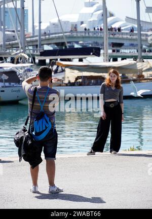 Barcelona, Spanien - 26. Mai 2022: Porträt des Ehepaares vor dem Hintergrund der fliegenden Boote und Möwen lächelt das junge rothaarige Mädchen während BE Stockfoto