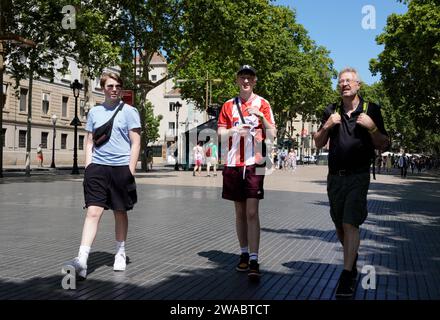 Barcelona, Spanien - 26. Mai 2022: Junger Mann mit einem Fußballtrikot hebt sich unter seinen Begleitern durch seine bunte Show End of the ramblas in Barce hervor Stockfoto