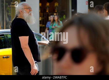 Barcelona, Spanien - 26. Mai 2022: Mann mit langen geflochtenen Haaren und reichlichem und langem weißen Bart, schaut ernsthaft durch seine runde Brille auf die Stockfoto