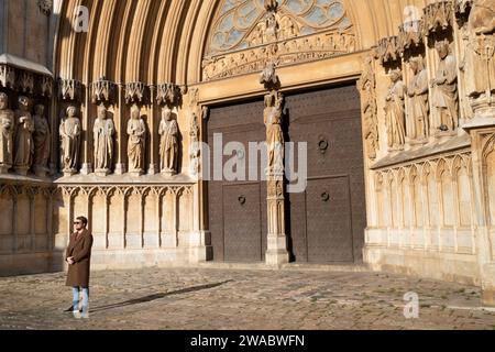 Tarragona, Spanien - 14. Januar 2022: Ein Mann im Mantel posiert vor den Heiligen vor der Tür der Kathedrale von Tarragona, religiöse Denkmäler touri Stockfoto