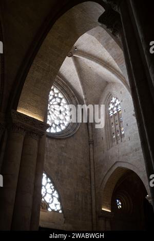 Tarragona, Spanien - 14. Januar 2022: Die Innenräume der Kathedrale von Tarragona verströmen eine mystische Atmosphäre mit farbenfrohen Buntglasfenstern und Monumenten Stockfoto