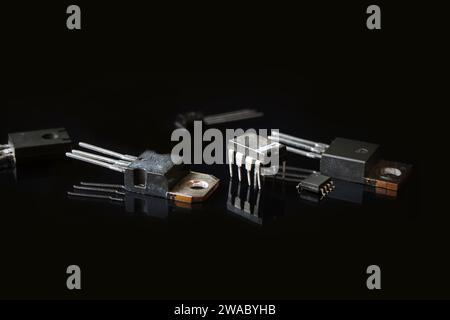 Halbleitermikroschaltungen. Integrierte Schaltung und Transistoren mit Reflexionen auf einem schwarzen. Elektronische Bauteile. Stockfoto