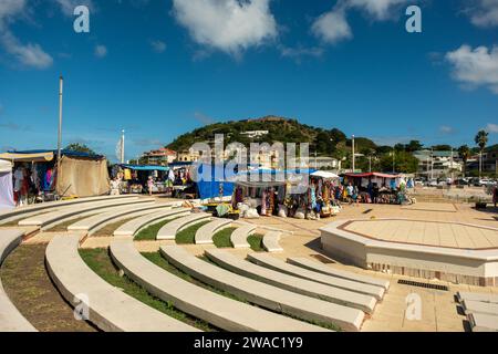 MARIGOT, SAINT MARTIN - 4. Dezember 2023: Auf der einen Seite der französischen Stadt Marigot befinden sich malerische alte Geschäfte und Marktstände. Auf der anderen Straßenseite ist dieser Mod Stockfoto