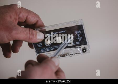Madrid, Spanien. 2. Januar 2024 man spult mit einem Stift eine alte alte Kassette für Kassettenrekorder zurück. Nostalgie für 90er, 00er Jahre Hören Sie Musik Stockfoto