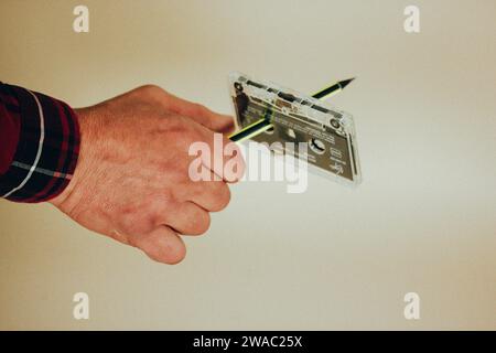 Madrid, Spanien. 2. Januar 2024 man spult mit einem Stift eine alte alte Kassette für Kassettenrekorder zurück. Nostalgie für 90er, 00er Jahre Hören Sie Musik Stockfoto