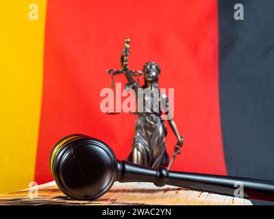 Der Hammer des Richters liegt auf 50-Euro-Scheinen vor dem Hintergrund der deutschen Flagge. Recht und Gerechtigkeit. Stockfoto