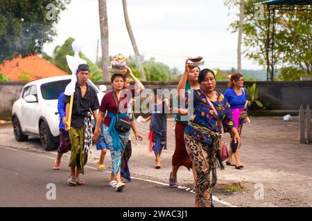 Eine Beerdigungszeremonie auf der Insel Bali. Menschen in traditionellen bunten Outfits ziehen Schmuck und einen Körper zur Einäscherung an. Bali, Indonesien - 12.11.2022 Stockfoto