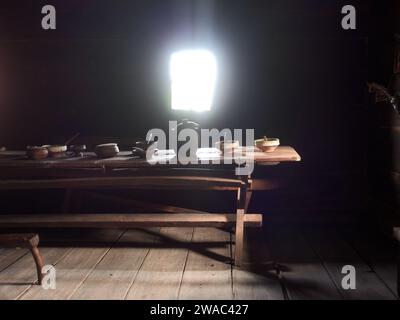 Alter Tisch aus massivem Holz mit Töpferwaren, Tonschalen und Holzlöffeln im traditionellen serbischen Haus im Freilichtmuseum Old Village, Sirogojno, Serbien Stockfoto