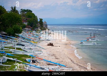 Auf einer indonesischen Insel stehen traditionelle Katamaranboote mit einheimischen Farben an der Küste des Meeres Stockfoto