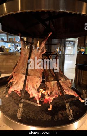 Lammkochen am offenen Feuer alias Lamb al asador in einem Restaurant El Chalten. El Chalten.Provinz Santa Cruz.Patagonien.Argentinien Stockfoto