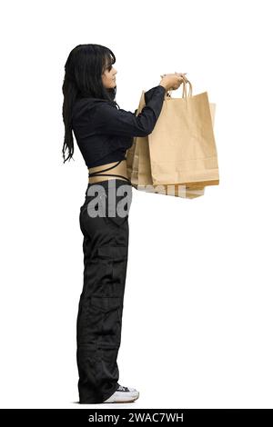 Eine Frau in schwarzer Kleidung, auf weißem Hintergrund, in voller Länge, mit Taschen Stockfoto