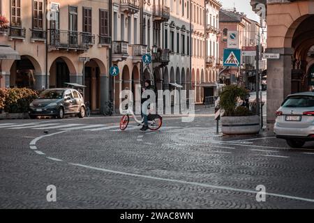 Padua, Italien - 4. April 2022: Senior Tourist macht Fotos in den historischen Straßen von Padua mit einem Leihfahrrad, das von der Stadt zur Verfügung gestellt wird. Stockfoto