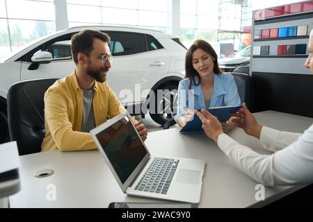 Ehepartner formalisieren einen Deal im Bürobereich des Autohändlers Stockfoto