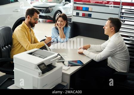 Käufer schließen ein Geschäft im Bürobereich des Autohändlers ab Stockfoto