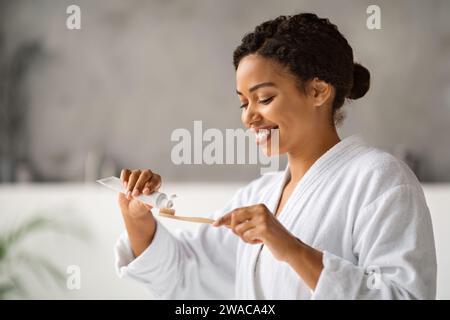 Mundhygiene. Schöne Schwarze Frau, Die Zahnpasta Auf Eco Bamboo Zahnbürste Aufsetzt Stockfoto