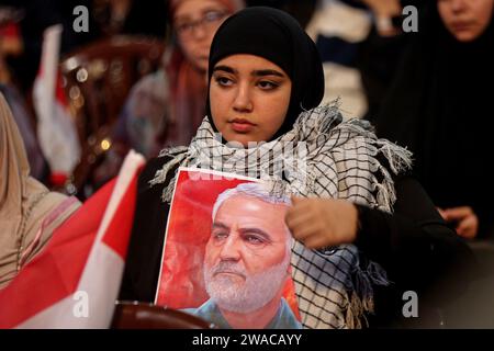 Beirut, Libanon. Januar 2024. Ein pro-iranischer Hisbollah-Unterstützer trägt den palästinensischen Koffiyeh und hält ein Bild des ermordeten Befehlshabers der iranischen Quds-Force Qasem Soleiman während einer Massenveranstaltung anlässlich seines 4. Todestages mit Abu Mahdi al-Mohandes, dem stellvertretenden Leiter der irakischen Haschd al-Shaabi-Miliz, in der Hand. von einer US-Drohne im Irak im Jahr 2020. Quelle: Marwan Naamnai/dpa/Alamy Live News Stockfoto