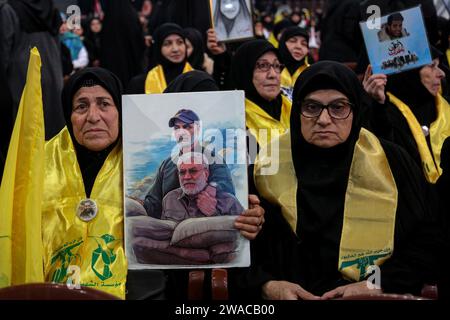 Beirut, Libanon. Januar 2024. Ein pro-iranischer Hisbollah-Unterstützer hält ein Bild, das sowohl den ermordeten Abu Mahdi al-Mohandes, den stellvertretenden Leiter der irakischen Hashd al-Shaabi-Miliz, als auch den iranischen Quds-Force-Befehlshaber Qasem Soleiman während einer Massenzeremonie anlässlich ihres 4. Todestages durch eine US-Drohne im Irak im Jahr 2020 zeigt. Quelle: Marwan Naamnai/dpa/Alamy Live News Stockfoto