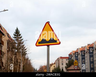 Holpriges Straßenschild in Polen. Fahren Sie mit Vorsicht, da die Straße schlecht ist und gefährliche Umstände für Verkehrsteilnehmer oder Geschwindigkeitsrampen auftreten. Stockfoto