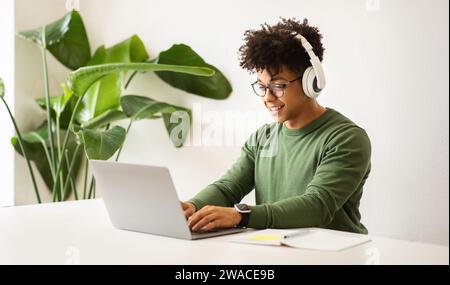 Positiver Millennial Black man Entwickler, der im Home Office arbeitet Stockfoto