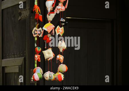 Japanische Landschaft hängende Zierpuppen vor dem Tor, die für das Puppenfestival „Hina Matsuri“ dekoriert sind, das ein Festival zum Beten ist Stockfoto