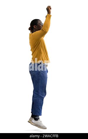 Ein Mann in einer gelben Jacke springt auf einen weißen Hintergrund, im Profil Stockfoto
