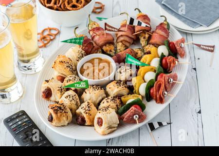 Zu den Vorspeisen am Spieltag gehören Schweine in einer Decke und Jalapeno-Poppers. Stockfoto