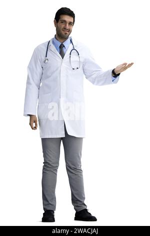 Männlicher Arzt auf weißem Hintergrund in vollem Wachstum zeigt zur Seite Stockfoto