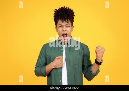 Ein afroamerikaner mit lockigen Haaren schlägt in die Luft Stockfoto