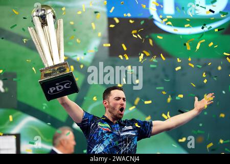 Luke Humphries feiert mit der Trophäe, nachdem er Luke Litttler im Finale der Paddy Power World Darts Championship im Alexandra Palace in London besiegt hat. Bilddatum: Mittwoch, 3. Januar 2024. Stockfoto