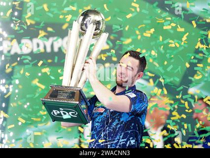 Luke Humphries feiert mit der Trophäe, nachdem er Luke Litttler im Finale der Paddy Power World Darts Championship im Alexandra Palace in London besiegt hat. Bilddatum: Mittwoch, 3. Januar 2024. Stockfoto