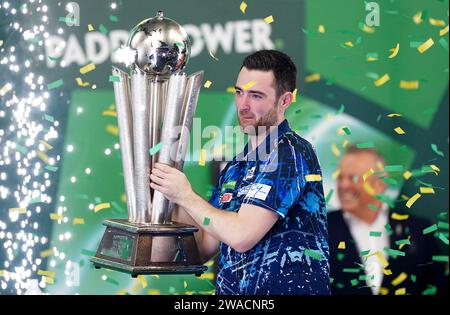 Luke Humphries feiert mit der Trophäe, nachdem er Luke Litttler im Finale der Paddy Power World Darts Championship im Alexandra Palace in London besiegt hat. Bilddatum: Mittwoch, 3. Januar 2024. Stockfoto