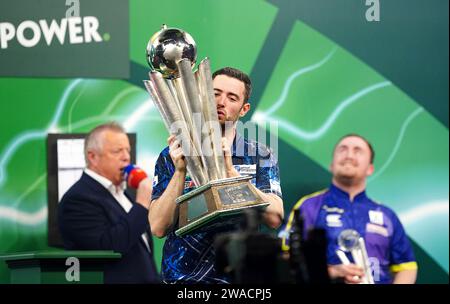 Luke Humphries feiert mit der Trophäe, nachdem er Luke Litttler im Finale der Paddy Power World Darts Championship im Alexandra Palace in London besiegt hat. Bilddatum: Mittwoch, 3. Januar 2024. Stockfoto