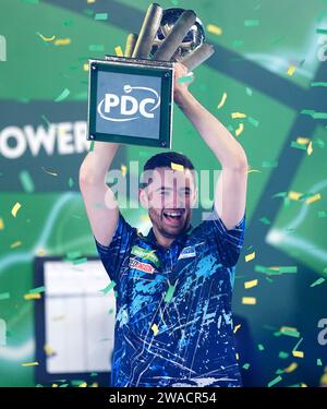 Luke Humphries feiert mit seiner Trophäe, nachdem er Luke Litttler im Finale der Paddy Power World Darts Championship im Alexandra Palace in London besiegt hat. Bilddatum: Mittwoch, 3. Januar 2024. Stockfoto