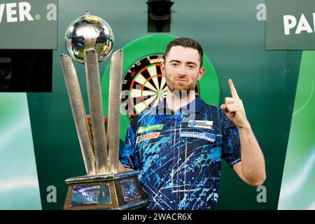 Luke Humphries feiert mit seiner Trophäe, nachdem er Luke Litttler im Finale der Paddy Power World Darts Championship im Alexandra Palace in London besiegt hat. Bilddatum: Mittwoch, 3. Januar 2024. Stockfoto