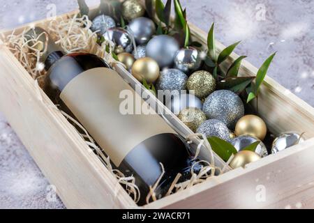 Weinflasche und weihnachtsschmuck in Holzkiste Stockfoto