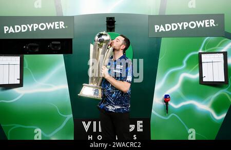 Luke Humphries feiert mit seiner Trophäe, nachdem er Luke Litttler im Finale der Paddy Power World Darts Championship im Alexandra Palace in London besiegt hat. Bilddatum: Mittwoch, 3. Januar 2024. Stockfoto