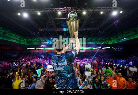 Luke Humphries feiert mit seiner Trophäe, nachdem er Luke Litttler im Finale der Paddy Power World Darts Championship im Alexandra Palace in London besiegt hat. Bilddatum: Mittwoch, 3. Januar 2024. Stockfoto