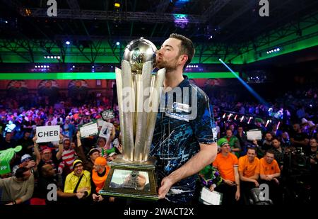 Luke Humphries feiert mit der Trophäe, nachdem er das Finale der Paddy Power World Darts Championship gegen Luke Litter im Alexandra Palace in London gewonnen hat. Bilddatum: Mittwoch, 3. Januar 2024. Stockfoto
