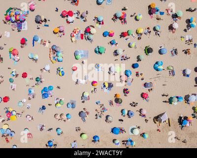 Von oben nach unten auf die Menschen, die sich am Strand an einem sonnigen Tag in der Costa da Caparica in der Nähe von Lissabon, Portugal, entspannen. Stockfoto