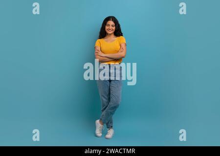 Stilvolle junge indische Studentin posiert auf blauem Hintergrund Stockfoto