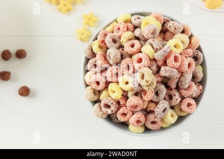 Farbenfroher Müsliring zum Frühstück auf weißem Tisch, Blick von oben Stockfoto