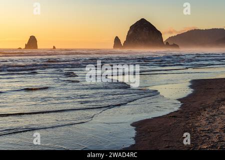 USA, Oregon, Haystack Rock am Cannon Beach bei Sonnenuntergang Stockfoto